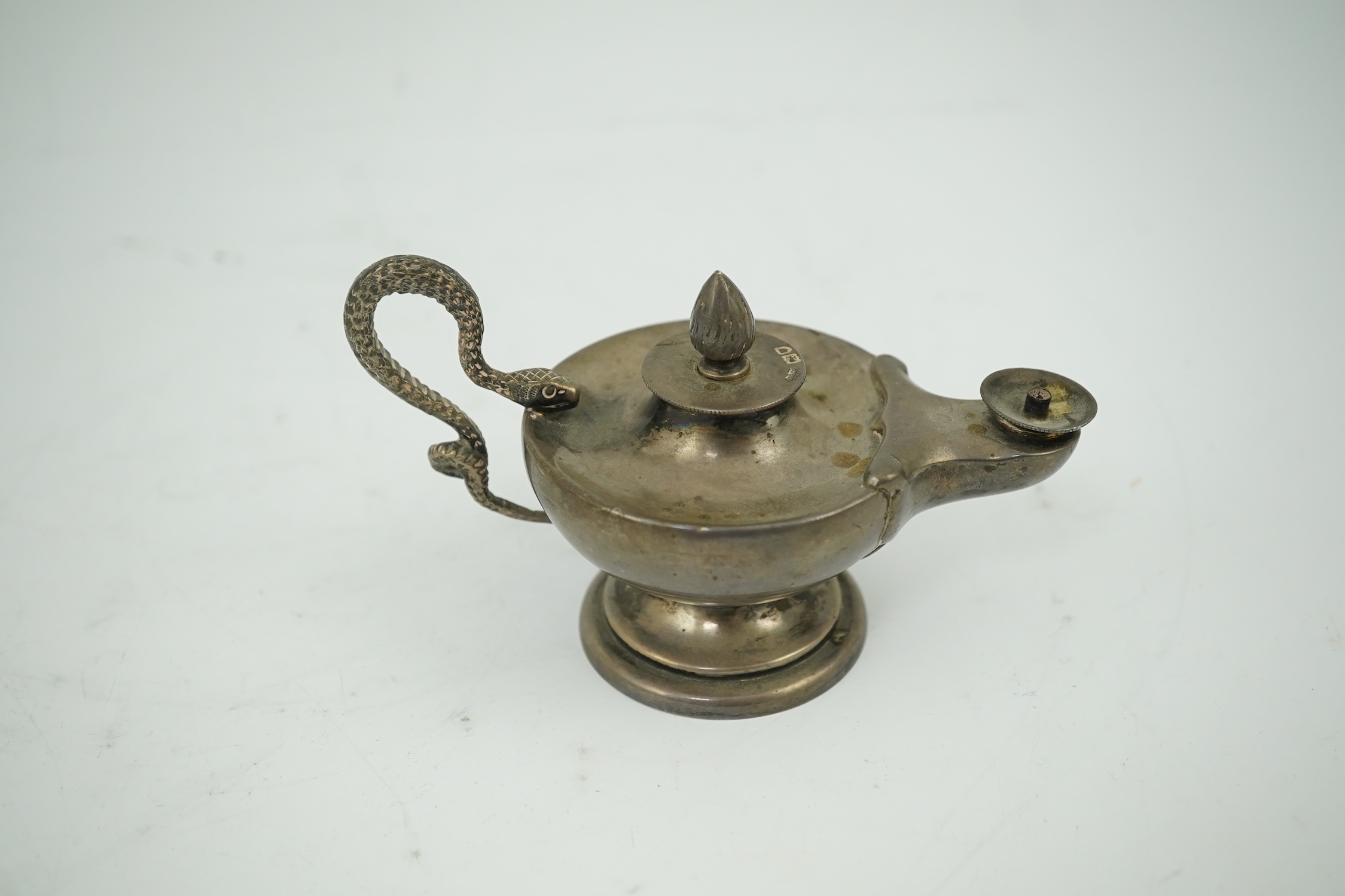 A late Victorian silver club lighter modelled as an oil lamp with serpent handle, Goldsmiths & Silversmiths Co Ltd, London, 1900, length 12cm. Condition - fair to good